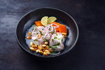 Traditional Peruvian gourmet ceviche sea bass filet piece with sweet potatoes and cancha marinated...