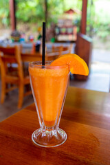 a glass of papaya juice with a straw