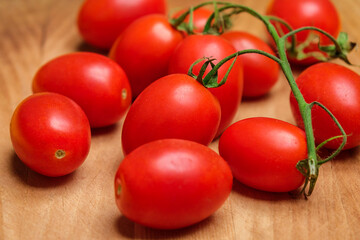 San marzano DOP cherry tomato branch with ripe, little tomatoes on a wooden cutting board.