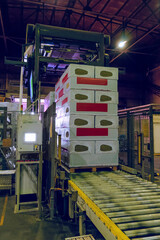 Packing rolling conveyor with stacked products. Thermal insulation mineral wool slabs laid and...