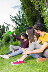 group of multiethnic people taking a selfie with smarphone. New normal covid-19 face mask lifestyle