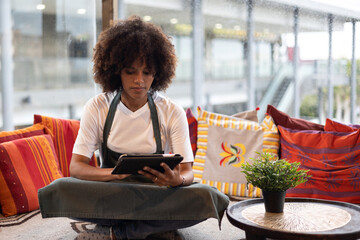 Portrait of young African waitress woman looking at a tablet in her leisure time.