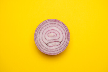Organic sliced red onion on a yellow background. Cool flat lay, copy space