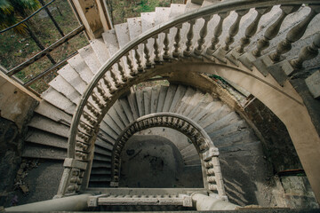 Top view of old vintage decorated spiral staircase in abandoned mansion - obrazy, fototapety, plakaty