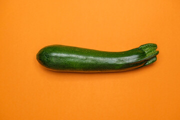 Organic green zuchini on orange background