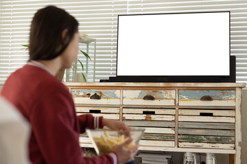 Fototapeta na wymiar Caucasian young woman having french fries and watching tv while sitting at home, copy space