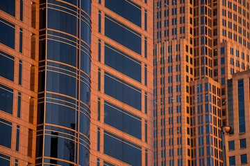 Fototapeta premium Captivating Reflection: Modern Office Skyscraper Shimmers in the Light of a Beautiful Evening Sky