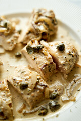 Chicken breasts in mustard sauce on white plate