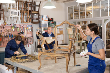 Portrait of skillful repair woman carpenter renovating chair furniture using tools in woodwork studio