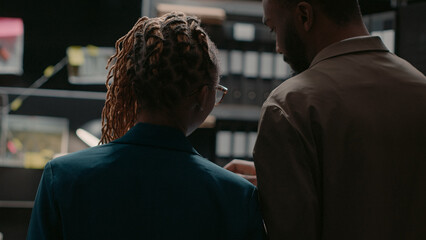 Cops examining evidence photos on detective board map and searching information to solve crime....