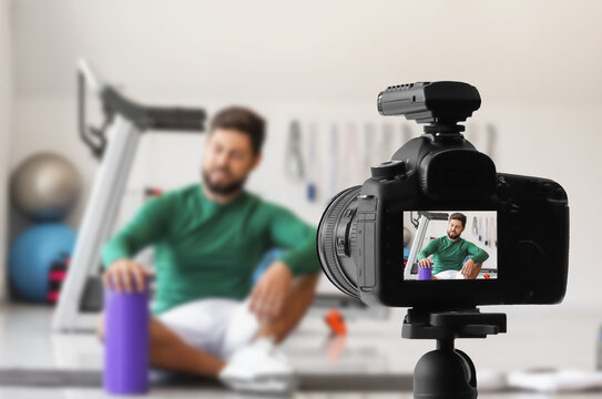 Male sports blogger recording video in gym