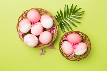 Fototapeta na wymiar Pink Easter eggs with decor on color background, top view