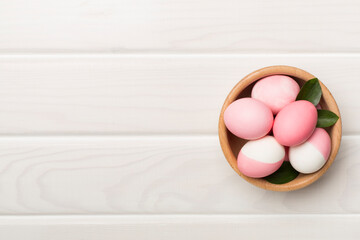 Pink Easter eggs with decor on wooden background, top view