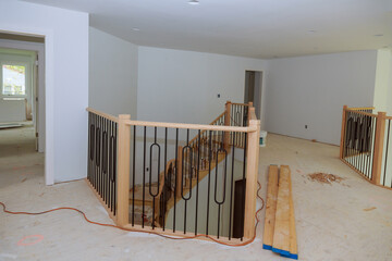 Large amount of progress is being made on assembly and installation of wooden railings in new house.