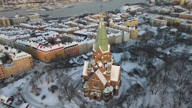 Aerial video above Sofia kyrka church in Stockholm Sweden. The capital city is covered in snow