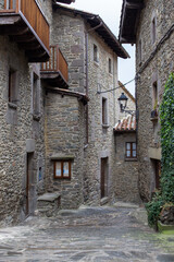 Calle de pueblo de montaña con ventanas balcones y farola