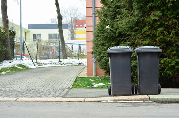 Fototapeta na wymiar View of garbage containers in city on winter day