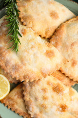 Plate with baked meat empanadas and rosemary, closeup