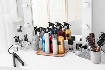 Hair sprays with accessories on table in beauty salon