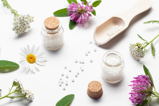 Composition of homeopathic medicines and medicinal plants on a white table