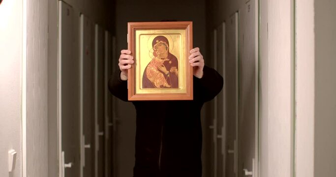 Religious unrecognizable person holds in hands an icon. No face. Religious Programs In Prison and Potential of Faith-Based Correctional models. Christians are concerned with the welfare of prisoners. 