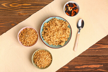 Bowls of tasty granola on wooden background