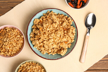 Bowls of tasty granola on wooden background