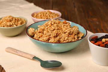 Bowls of tasty granola on wooden background