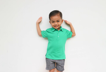 Portrait of a cute little Asian boy raising his hands while smiling and looking at the camera, isolated on the White Background