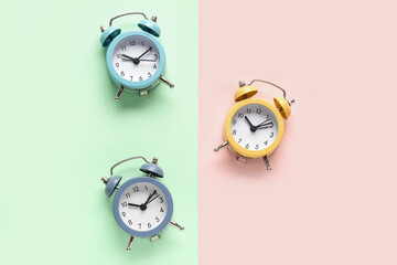 Three alarm clocks on color background