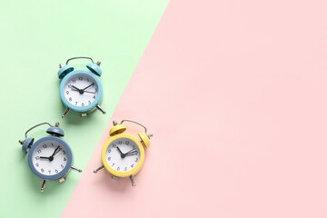 Three alarm clocks on color background