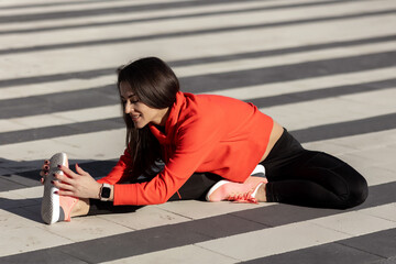 Fitness woman is fitness stretching and exercising outdoor in urban environment
