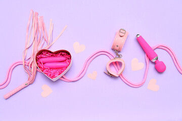 Gift box with sex toys and paper hearts on lilac background
