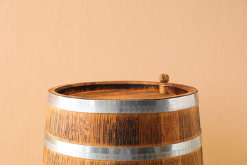 Wooden barrel on beige background, closeup