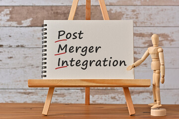 There is notebook with the word Post Merger Integration. It is an eye-catching image.