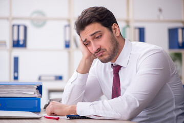 Fototapeta premium Young male employee and too much work in the office