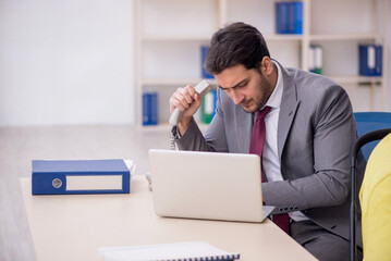 Young male employee looking after newborn at workplace