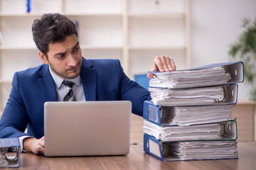 Young male employee and too much work in the office