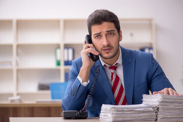 Young male employee and too much work in the office