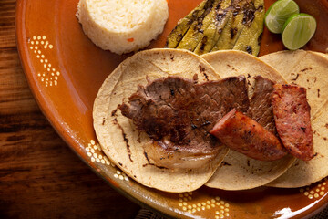 Roast meat tacos with Chorizo. Very popular dish in northern Mexico, also called Carne Asada, Asado, Discada or Parrillada, is a cooking technique in which food is exposed to the heat of the embers.