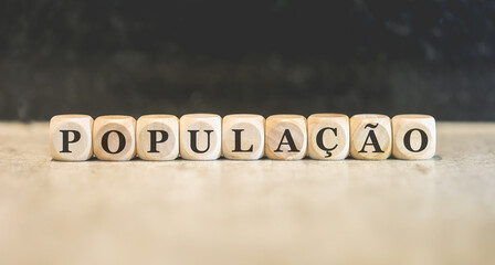 A palavra população em Português do Brasil escrita em dados de madeira.