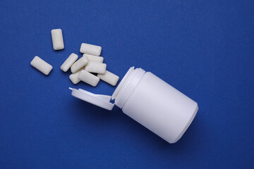 Jar with chewing gums on blue background, flat lay
