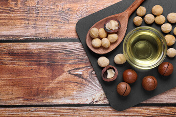 Delicious organic Macadamia nuts and natural oil on wooden table, top view