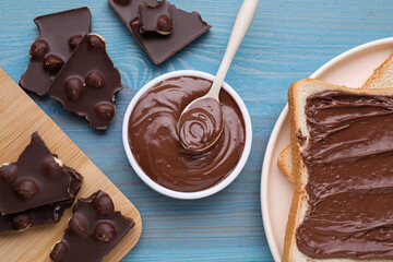 Flat lay composition with tasty chocolate and sweet paste served on light blue wooden table