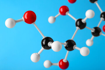 Molecule of glucose on light blue background, closeup. Chemical model