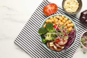 Delicious vegan bowl with broccoli, red cabbage and chickpeas on white marble table, flat lay. Space for text