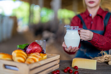 Young female dairy farmer hand holding jug of fresh milk , product concept from dairy farm