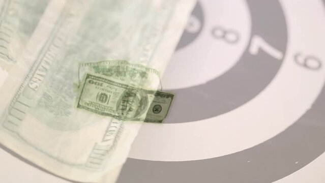 Animation of american dollar bills spinning over bull's eye