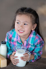 Asian girl drinking Fresh cow's milk that is produced from modern farms and dairy products. , product concepts from dairy farms and health