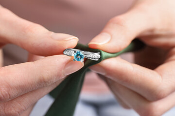 Jeweler cleaning topaz ring with microfiber cloth, closeup